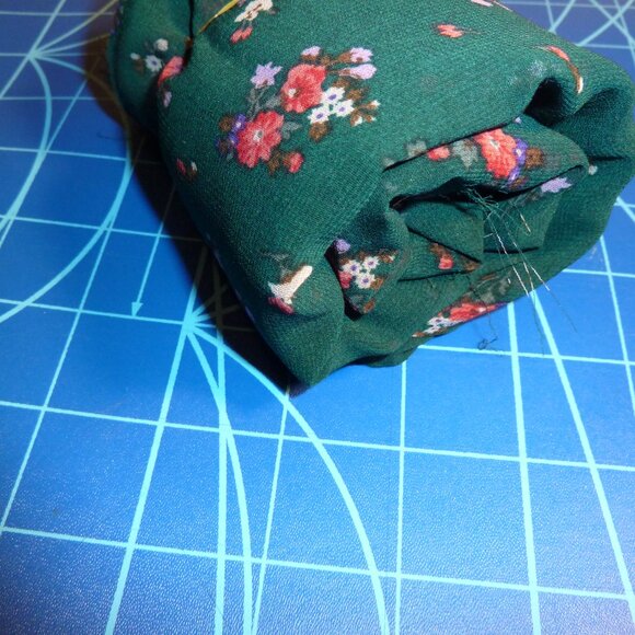 Fabric with pink, red, and fuchsia floral pattern on a forest green background - Picture 2 of 3